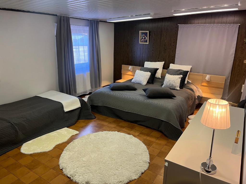 a bedroom with two beds and a white rug at Sandby in Karlholmsbruk