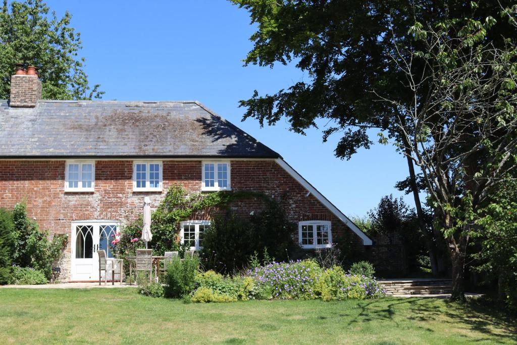 an old brick house with a garden in front of it at Piddle Cottage in Dorchester
