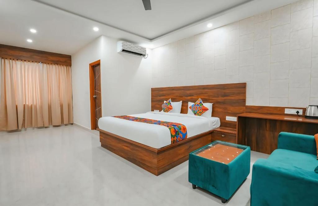 a bedroom with a bed and a blue couch at Hotel Vihara Inn in Bangalore