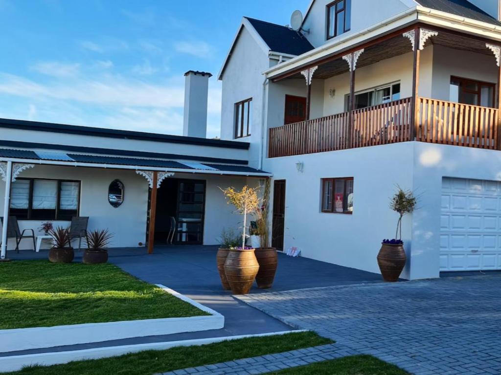 a white house with a balcony and a driveway at 7 on South in Bredasdorp