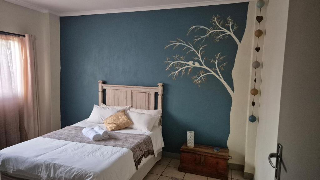 a bedroom with a bed with a blue wall at Herberg 5 in Vosburg