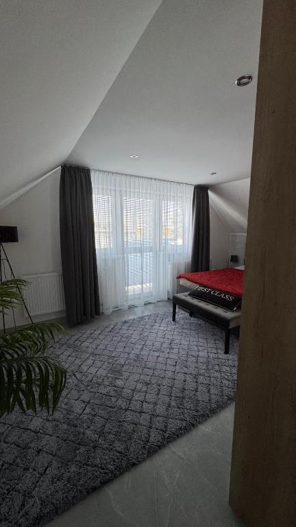 a bedroom with a red bed and a large window at Apartmán Noel in Soľ