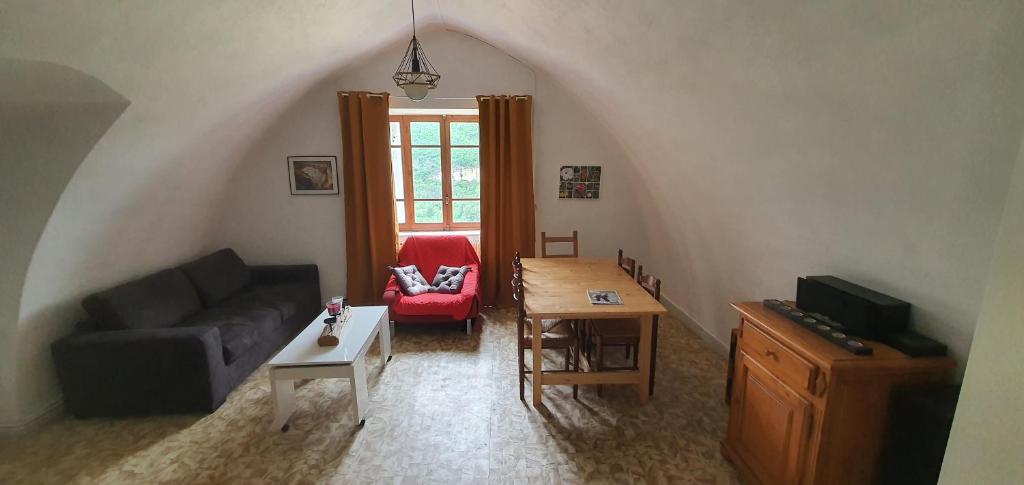 a living room with a couch and a table at Gîte des pêcheurs, Gorges du Tarn in Mostuéjouls