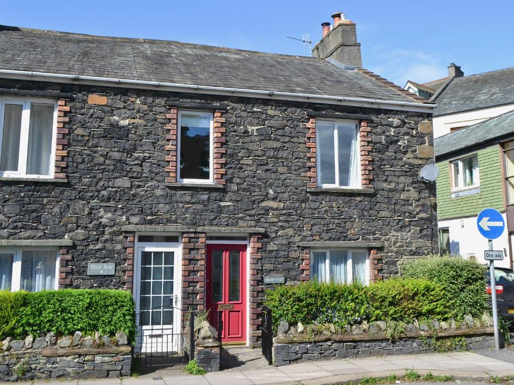 a stone house with a red door on a street at Beny Cot in Keswick