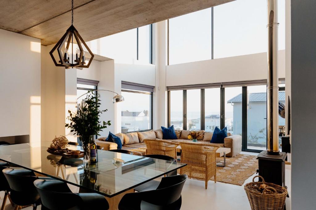 a living room with a glass table and blue pillows at Beyond The Beach in Yzerfontein