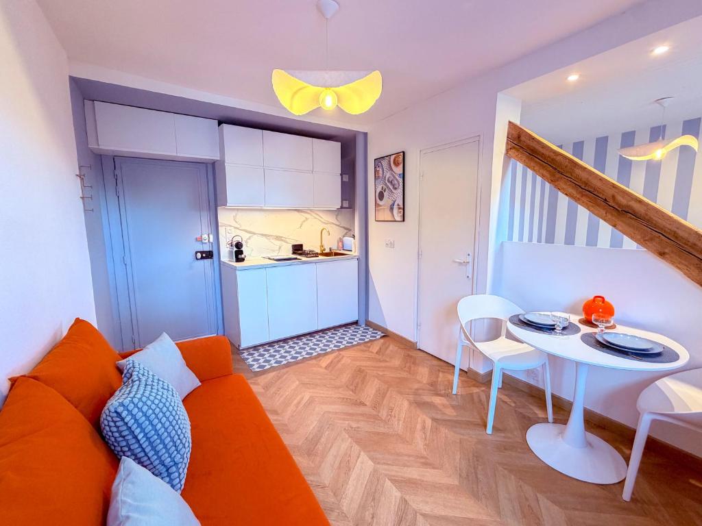 a living room with an orange couch and a table at Studio cosy proche des Thermes in Royat