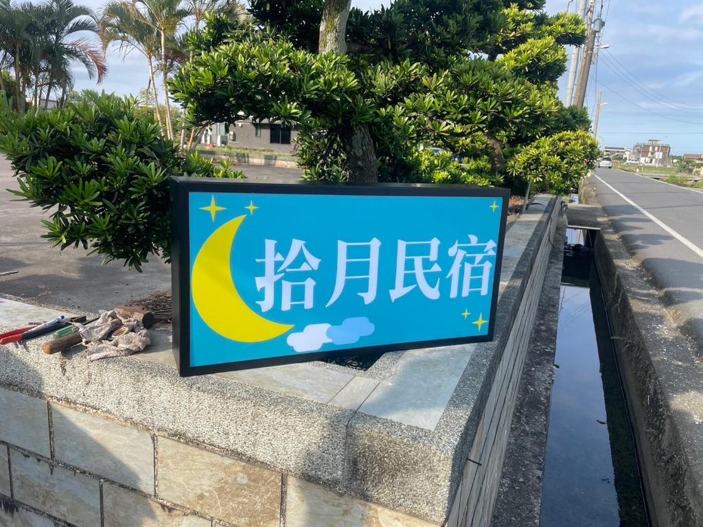 a sign on a wall next to a street at Shiyue Homestay in Zhuangwei