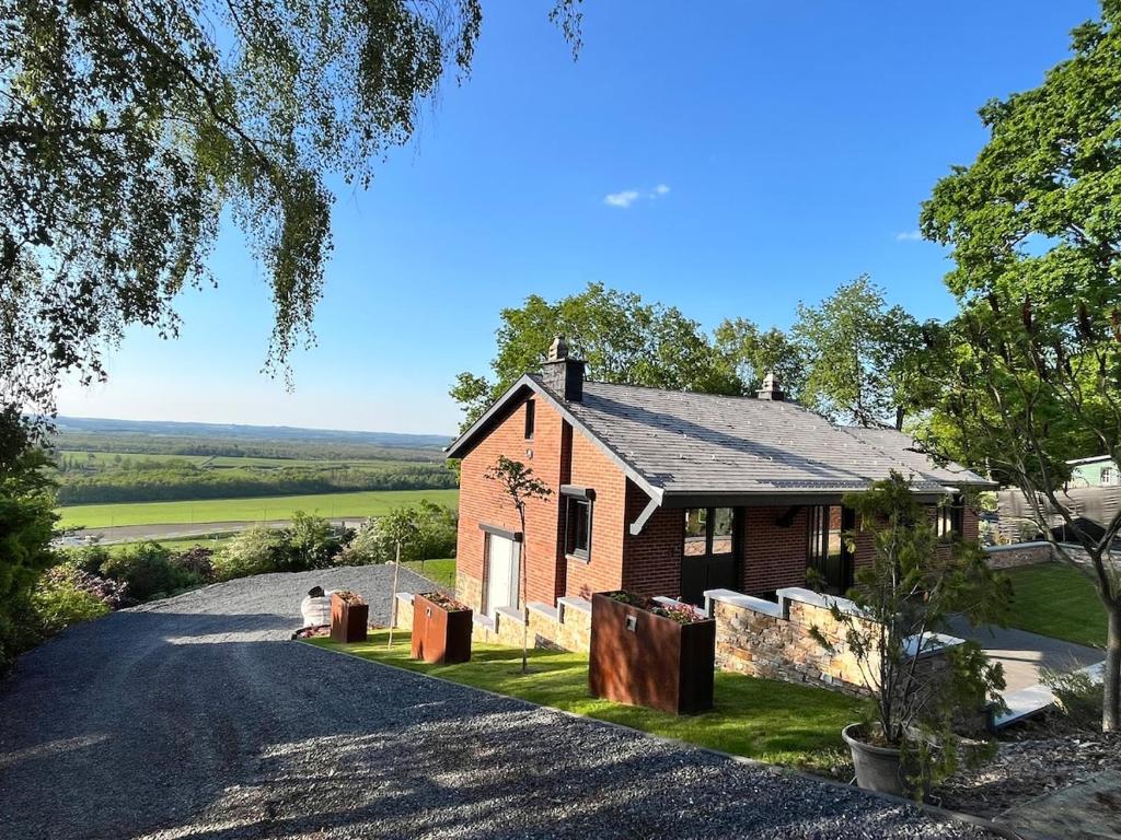 a red brick house with a driveway at Villa bel horizon avec jacuzzi in Hotton