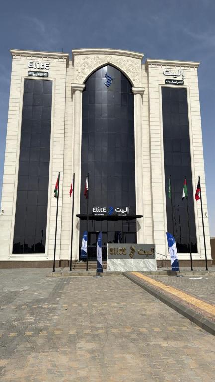 a large building with flags in front of it at إليت الجامعة -Elite Served Apartments - Hafar Al-Batin in Hafr Al-Batin