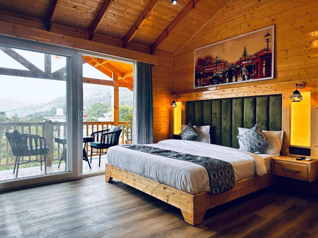 a bedroom with a large bed and a balcony at The Walnut Homes- Luxury Pine Cottages in Bhīm Tāl