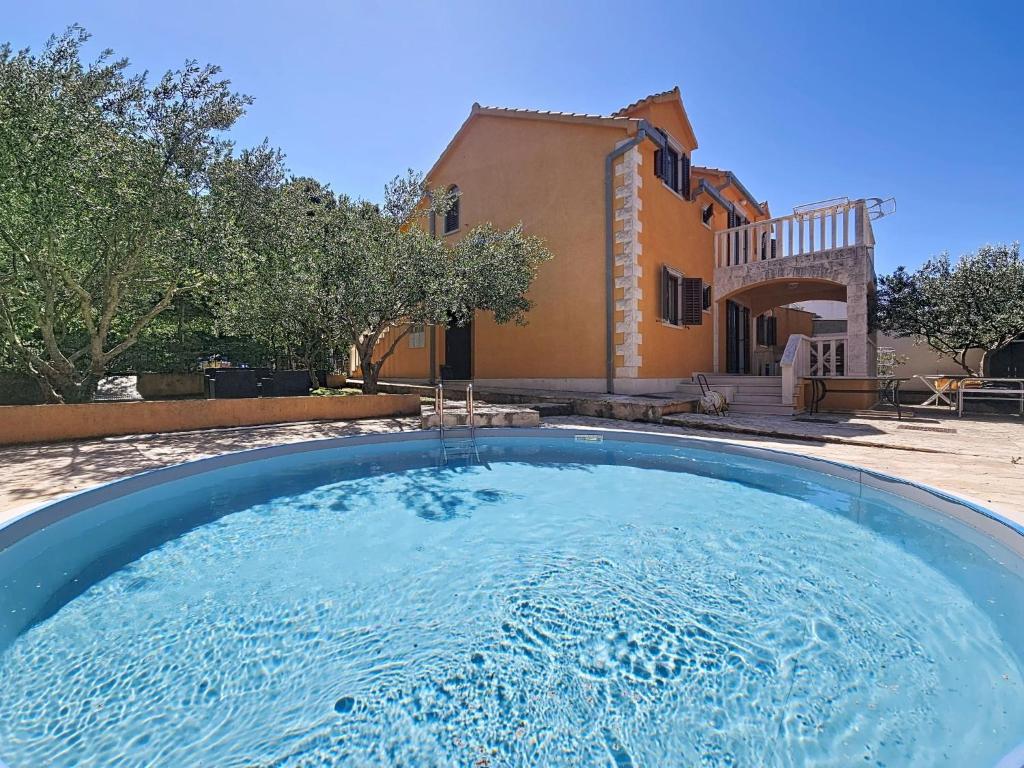 a large swimming pool in front of a house at Holiday Home Gorana by Interhome in Mirce