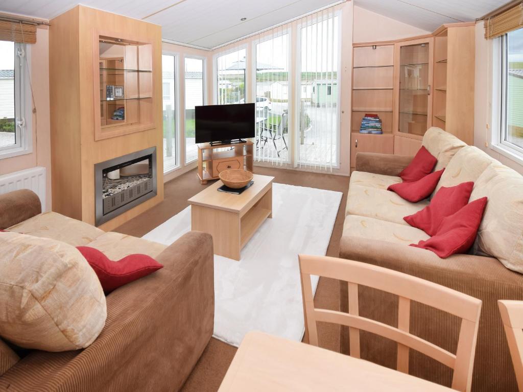 a living room with two couches and a fireplace at Stanley's Sanctuary in Boot