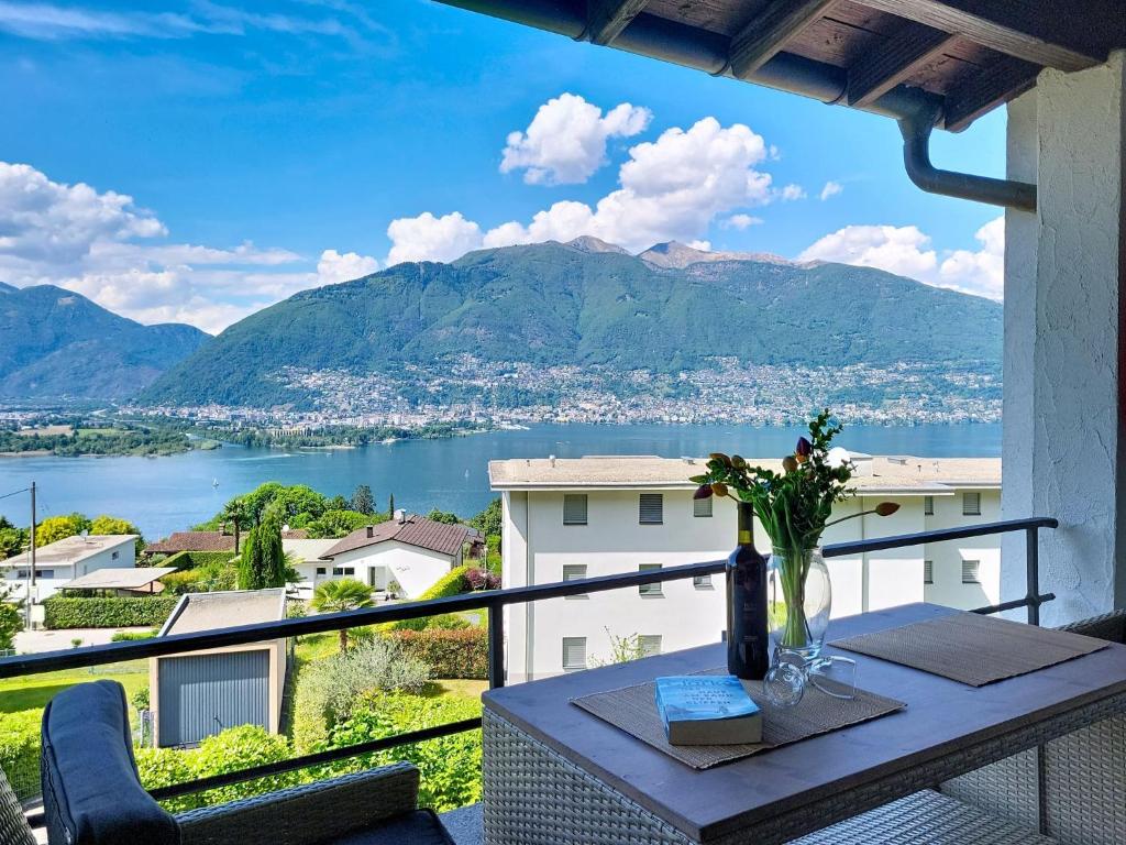 a balcony with a table and a view of the water at Apartment Residenza Miralago Apt- C27 by Interhome in Piazzogna