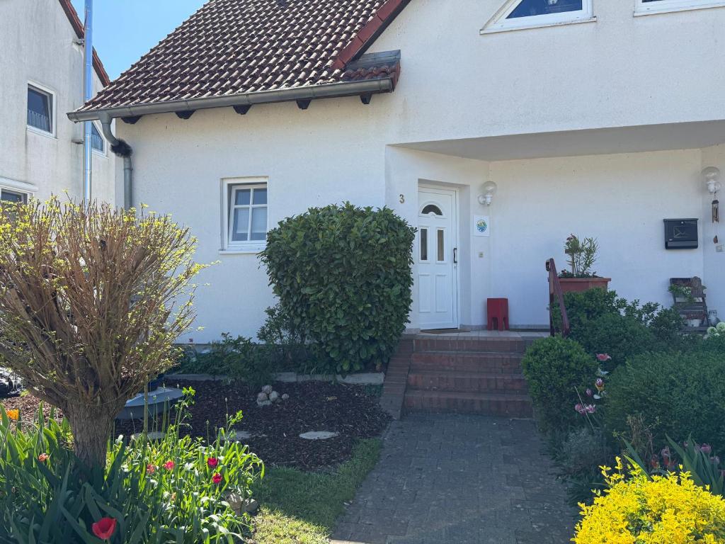 a white house with a white door and flowers at Ferienhaus im Fischersteig in Wustrow