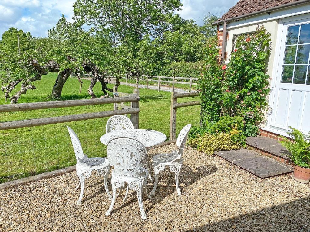 a table and chairs sitting on a gravel patio at Orchard Barns in North Nibley