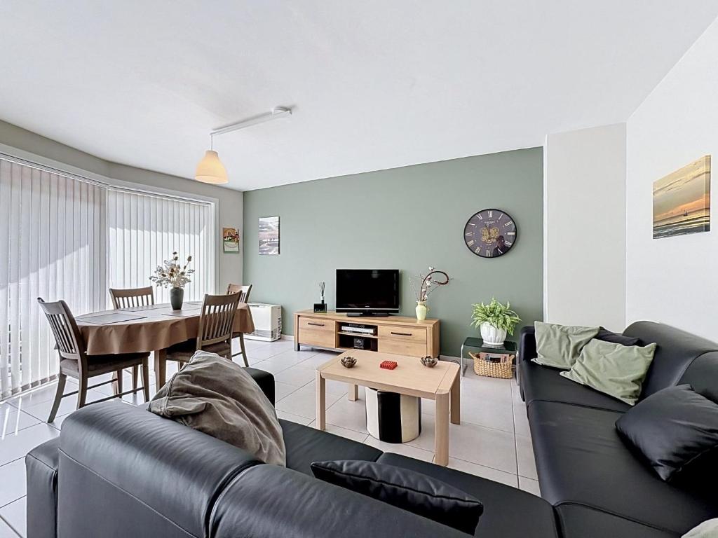 a living room with a couch and a table at Apartment Westhinder with balcony by Interhome in Blankenberge