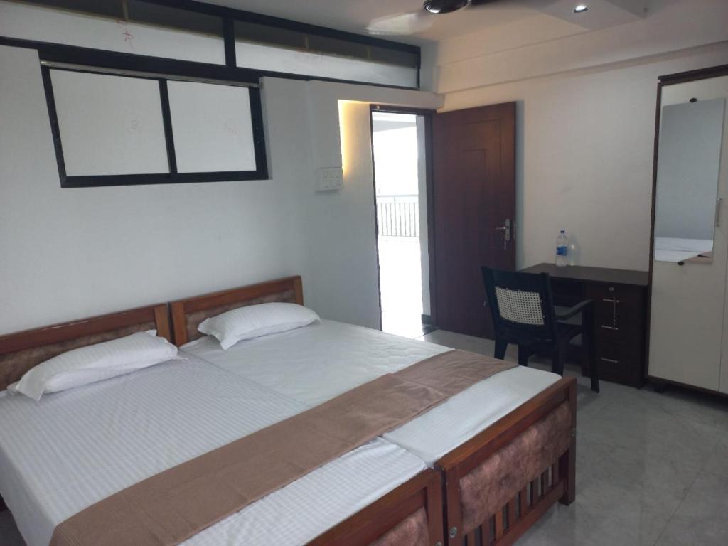 a bedroom with a large bed and a desk and a desk at Serene Enclave in Nedumbassery