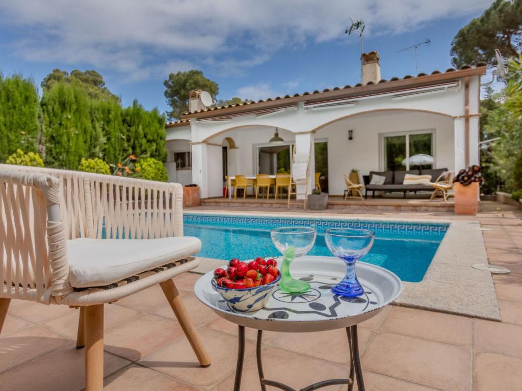 a villa with a swimming pool and a table with wine glasses at Holiday Home Florencia by Interhome in Pals