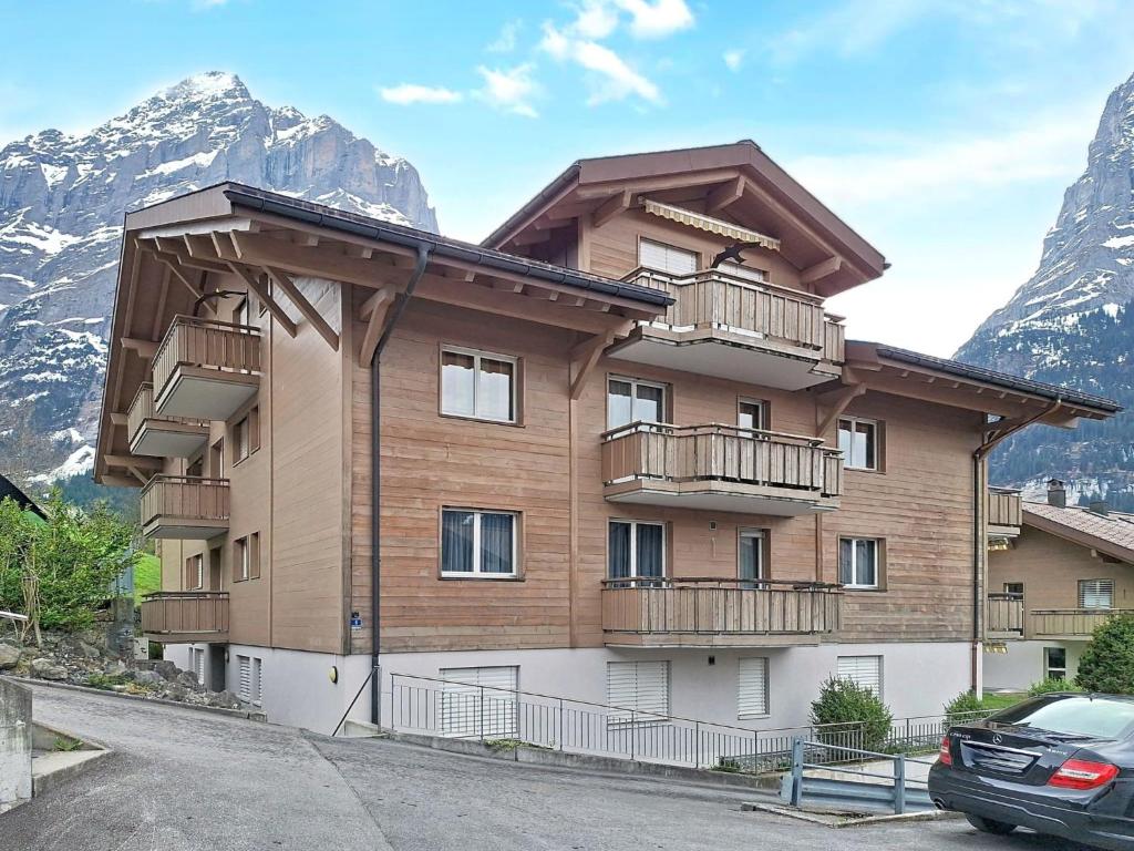 a apartment building with balconies and mountains in the background at Apartment Sans Souci W1 by Interhome in Grindelwald