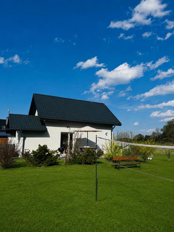 a white house with a net in a yard at Domek Pod Gwiazdami Bieszczady in Hużele