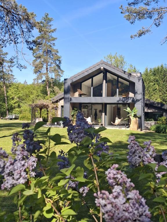 a house with a garden with purple flowers at Domaine Plan Bois in Ballaison