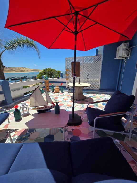 a red umbrella sitting on top of a patio at lagoon apartement 1 in Moulay Bousselham