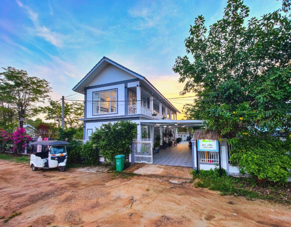 a blue house with a porch and a driveway at Kampot Origin in Kampot