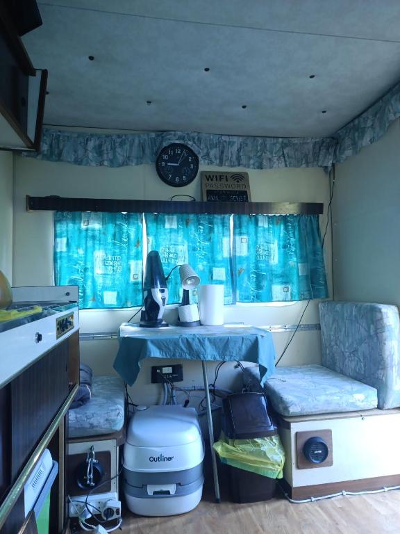 a kitchen with a table and two seats in a rv at Yupfssi camp in Riga