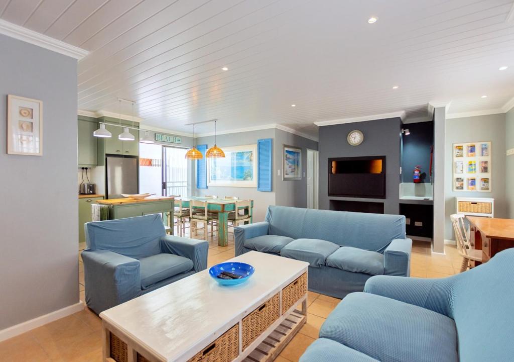 a living room with blue couches and a table at Helios House in Langebaan