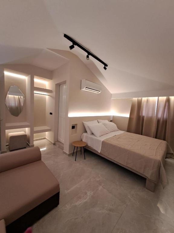 a bedroom with a bed and a couch in it at Acapulco Marinos Apartments- Adults Only in Laganas