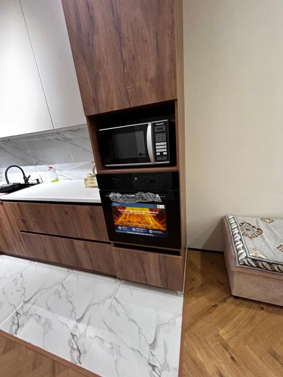 a microwave oven in a cabinet in a kitchen at River city-Сайран in Almaty