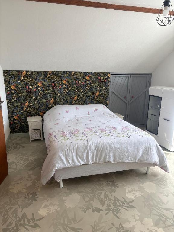 a bedroom with a bed with a painting on the wall at Cozy apartment in Germainville