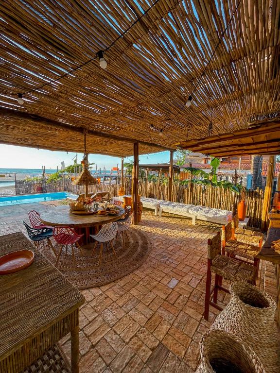 a patio with a table and chairs and a wooden umbrella at Casa Monã in Maceio