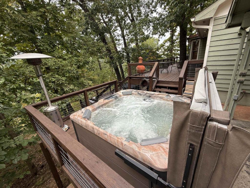 a hot tub on the deck of a house at Cozy Beaver Lake Getaway in Lowell