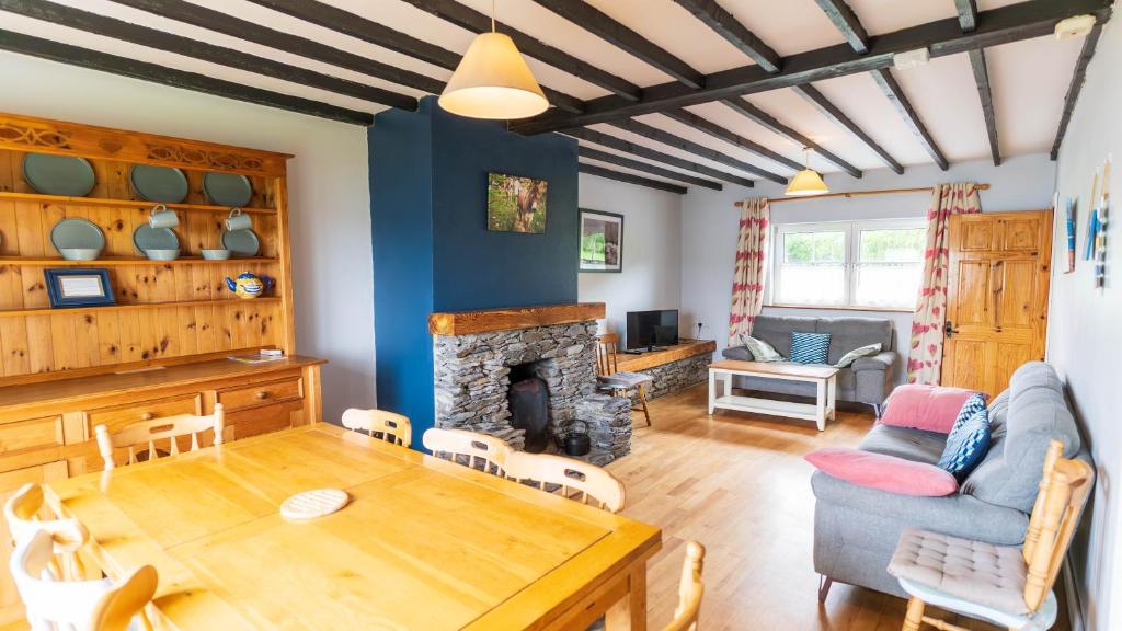 a living room with a table and a fireplace at Crab Cottage - Portmagee in Lateeve
