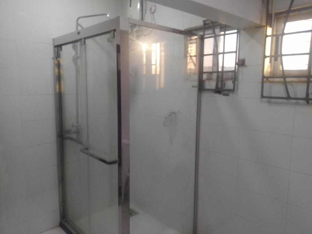 a shower with a glass door in a bathroom at Edo Global Boutique apartment in Benin City