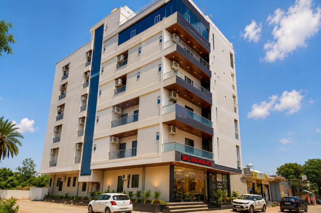 a white building with cars parked in front of it at Hotel Shree Radhe Mohan And Resort in Khātu