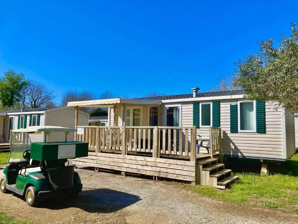 a house with a green lawn mower in front of it at De Pujol Greenchalets Argeles sur Mer in Argelès-sur-Mer