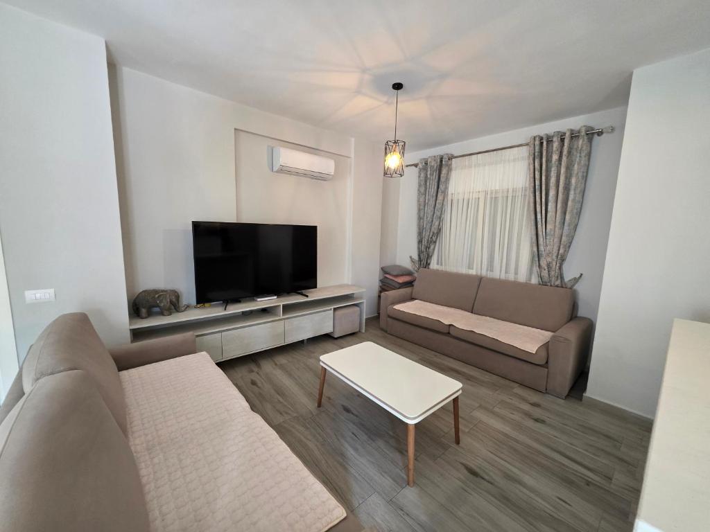 a living room with a couch and a flat screen tv at PERLA Vision Resort in Draç
