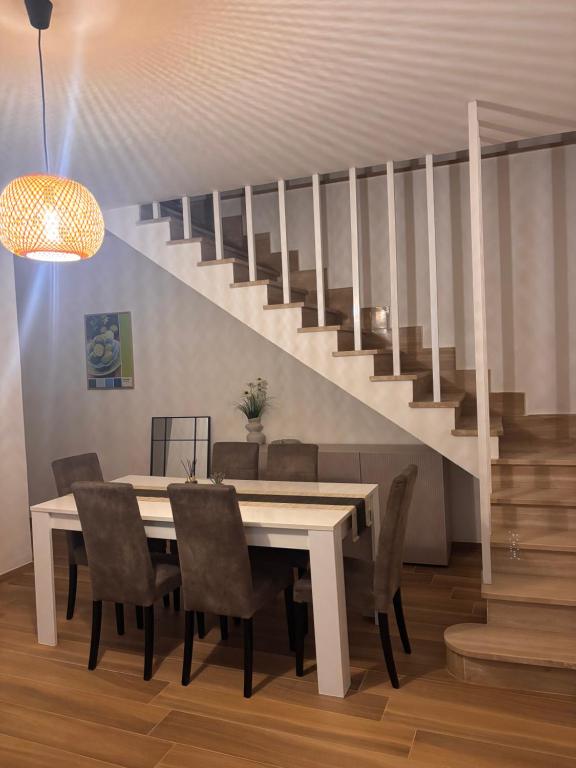 a dining room with a table and a staircase at De Chri House in Cisterna di Latina