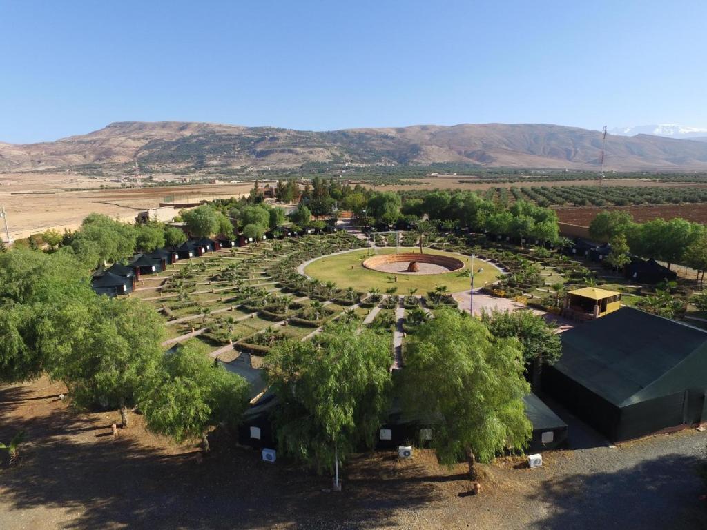an aerial view of a park with trees and a monument at Domaine Couleurs Berbères, Piscine, Vue Atlas, Bivouac & Expériences à Lalla Takerkoust in Lalla Takerkoust