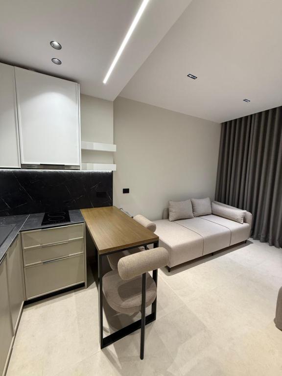 a living room with a couch and a table at Maison Apartments in Vlorë