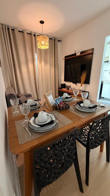 a dining room table with plates and glasses on it at Aracaju Apartamento 2 Quartos Proximo A Orla de Atalaia Praia de Aruana Aeroporto Shopping Sul in Aracaju