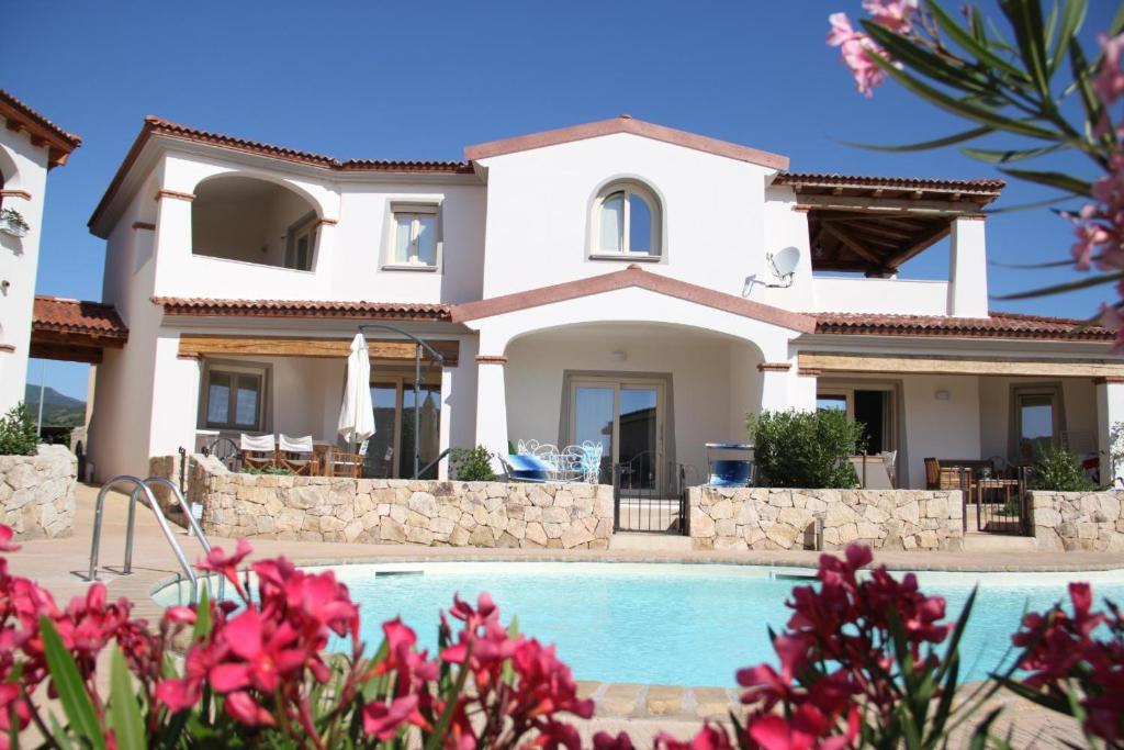 a villa with a swimming pool in front of a house at Mediterranean Sea Shell Pool House in Budoni