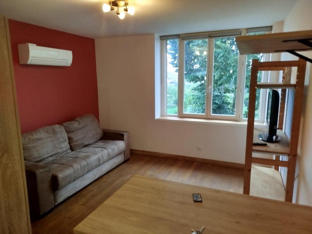 a living room with a couch and a window at Small modern air-conditioned cocoon in Châteauroux