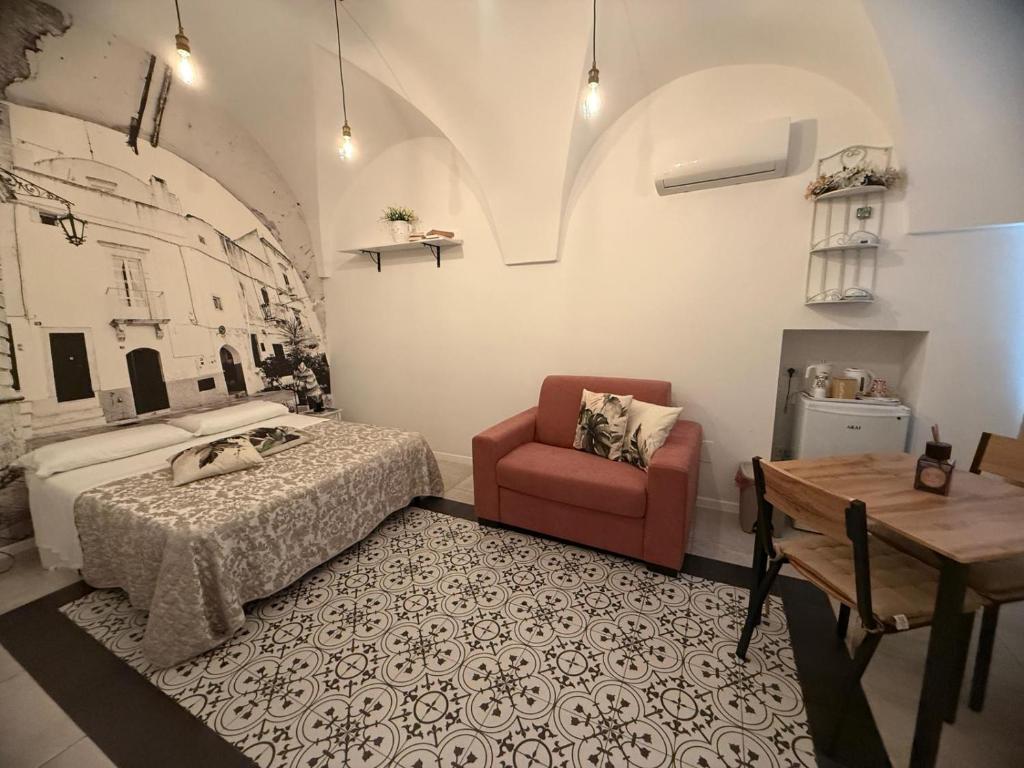 a bedroom with a bed and a chair and a table at da Nonna Lata in Martina Franca
