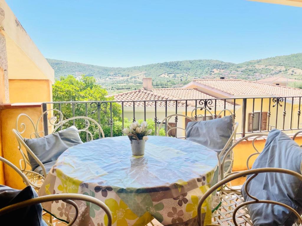 a table with a vase of flowers on a balcony at New Orange Studio 9 in Budoni