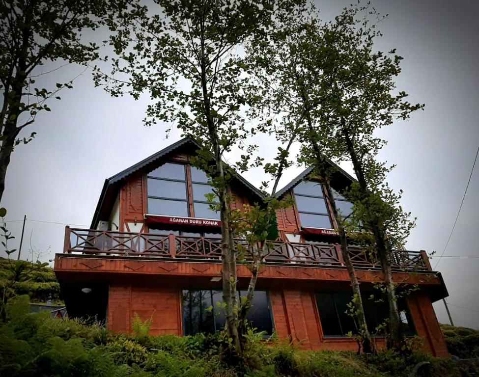 a house with a balcony on top of it at Ağaran Duru Konak Suit Bungalov in Rize