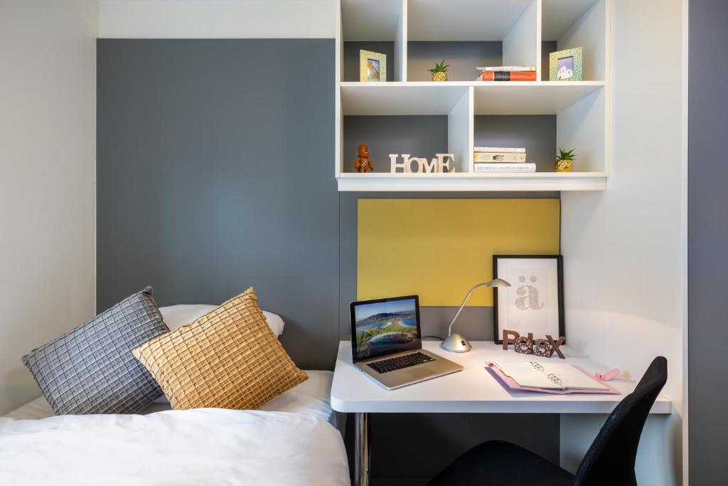a bedroom with a desk with a laptop on a bed at Canvas Cúirt na Coiribe Galway in Galway