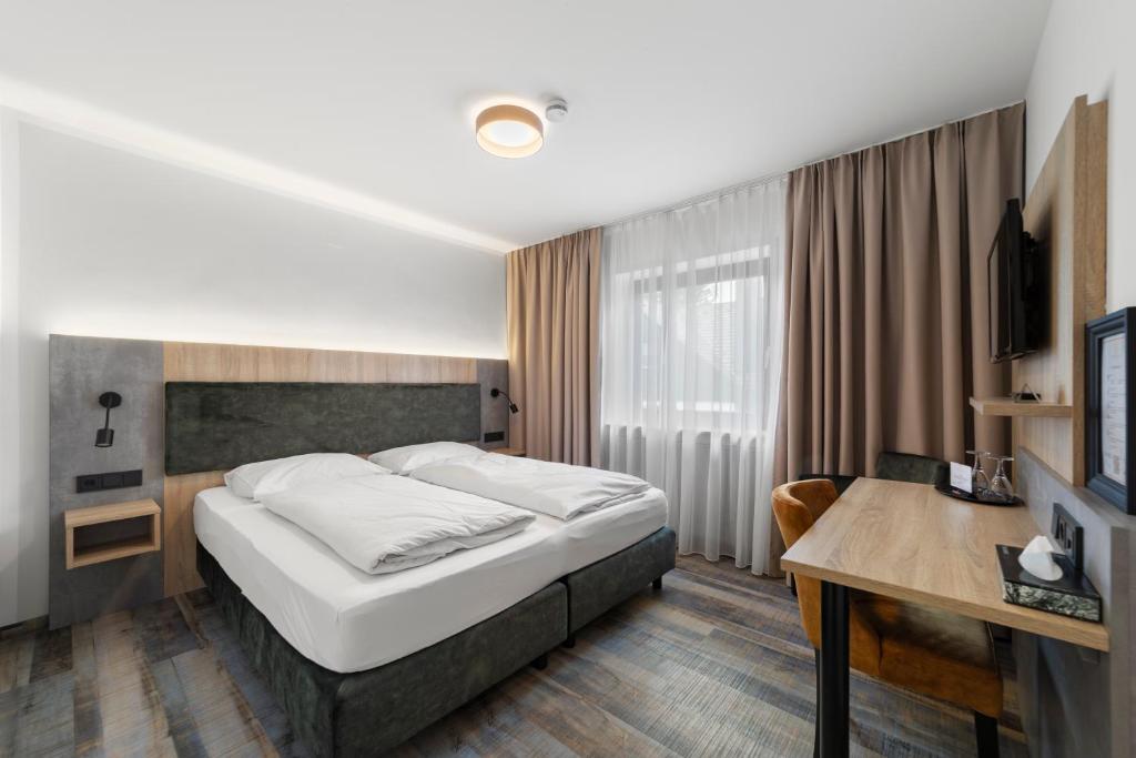 a hotel room with a bed and a desk at Hotel Franken in Forchheim